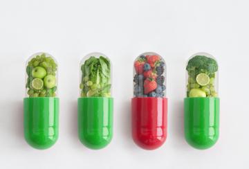 3 green capsules filled with green fruit and vegetables, 1 red capsule filled with berries